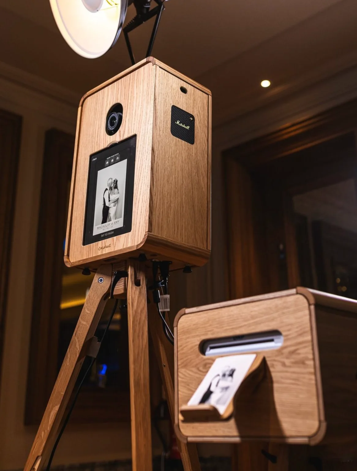 Photo booth in legno con schermo personalizzato e fotografia in uscita dalla stampante