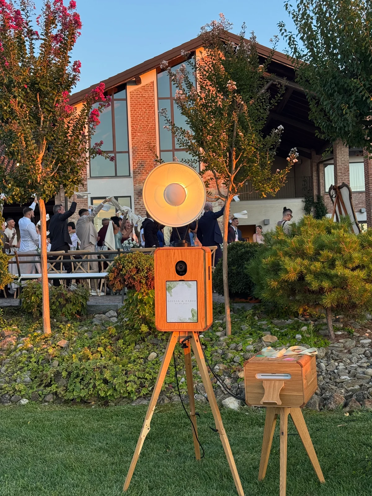 Photo booth e stampante allestiti in giardino durante una festa di matrimonio