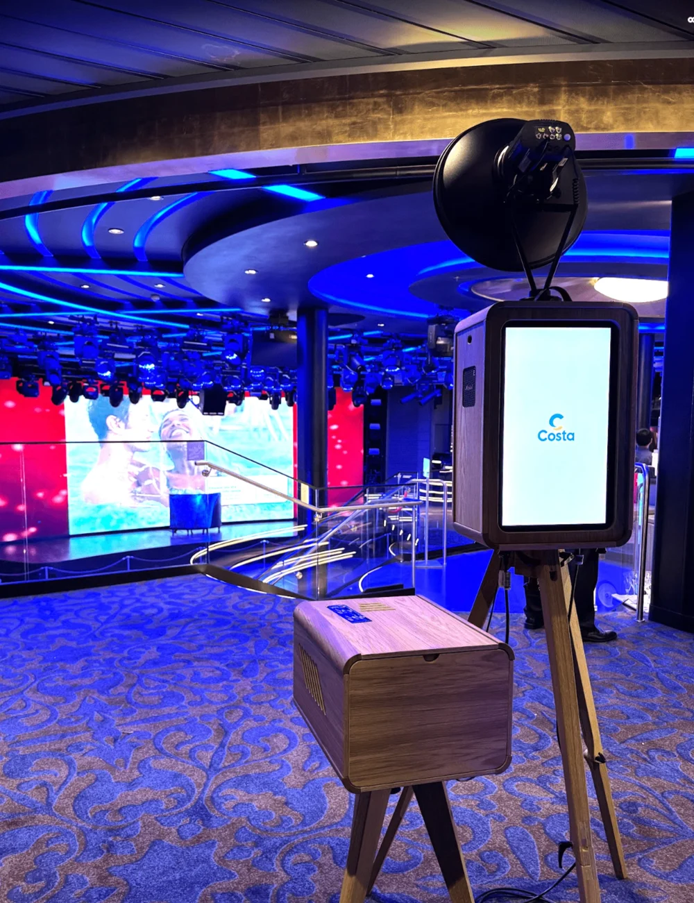 Photo booth e stampante in una sala con illuminazione blu